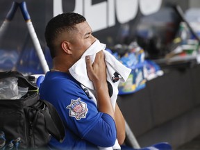 Chicago Cubs starting pitcher Jose Quintana wipes his face as he sits in the dugout after leaving the team's baseball game against the Chicago White Sox during the sixth inning Friday, Sept. 21, 2018, in Chicago.