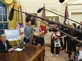 President Donald Trump, left, joined by FEMA Administrator Brock Long, second from left, and Homeland Security Secretary Kirstjen Nielsen, center, speaks during a briefing on Hurricane Florence in the Oval Office of the White House in Washington, Tuesday, Sept. 11, 2018.