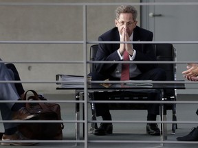 FILE-- In this Wednesday, Sept. 12, 2018 photo Hans-Georg Maassen, center, head of the German Federal Office for the Protection of the Constitution, waits for the beginning of a hearing at the home affairs committee of the German federal parliament, Bundestag, in Berlin, Germany. The leaders of Germany's three governing parties are meeting in Berlin on Tuesday to decide the fate of the country's domestic intelligence chief amid calls for him to be fired over his approach to far-right extremism.