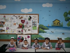 File - In this Wednesday, Aug. 29, 2018 file photo, girls sit inside a classroom at an UNRWA school during the first day of a new school year in Gaza City. A spokesman for the Palestinian president says the American decision to cut funding for the U.N. agency aiding Palestinian refugees is "an attack on the rights of the Palestinian people." The U.S. supplies nearly 30 percent of the total budget of the U.N. Relief and Works Agency, or UNRWA, and had been demanding it carry out significant reforms. The decision cuts nearly $300 million of planned support.