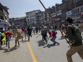 Indian policemen charge at Kashmiri Shiite Muslims participating in a religious procession in central Srinagar, Indian controlled Kashmir, Wednesday, Sept. 19, 2018. Police in Indian portion of Kashmir detained hundreds of mourners as they defied restrictions imposed by authorities, fearing religious processions marking the Muslim month of Muharram would turn into anti-India protests.