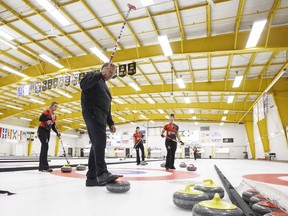 Coach Marcel Rocque raises his broom as, from left, Emma Miskew, Lisa Weagle, and Joanne Courtney, practice in Leduc, Alta., on Friday September 7, 2018.