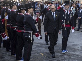 Regional Catalan President Quim Torra walks by the Catalan regional police 'Mossos D'Esquadra' honor guard, during celebrations of the Catalonia's regional holiday known as "La Diada" in Barcelona, Spain, Tuesday, Sept. 11, 2018.