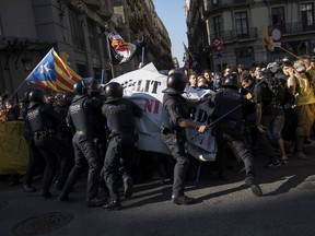 Catalan police officers try to stop pro independence demonstrators, on their way to meet demonstrations by member and supporters of the National Police and Guardia Civil in Barcelona on Saturday, Sept. 29, 2018.