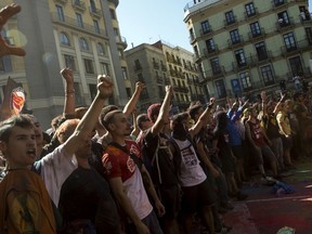 Pro independence demonstrators react as they are stop by Catalan police officers on their way to meet demonstrations by member and supporters of National Police and Guardia Civil, as coloured powder is seen in the air after being thrown by protesters, in Barcelona on Saturday, Sept. 29, 2018.