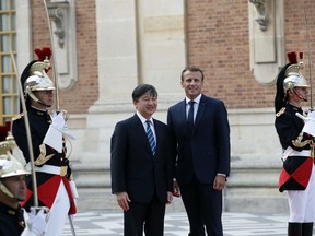 Japan's Crown Prince Naruhito, center left, is greeted by French President Emmanuel Macron before a meeting at the Chateau de Versailles, west of Paris, Wednesday, Sept. 12, 2018. Japan's Crown Prince Naruhito is for a nine-day goodwill visit in France.