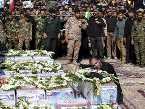 Father of Mohammad Taha Eghadami, a 4-year-old boy who was killed in Saturday's terror attack on a military parade, mourns over his coffin during a mass funeral ceremony for the victims, in southwestern city of Ahvaz, Iran, Monday, Sept. 24, 2018. Thousands of mourners gathered at the Sarallah Mosque on Ahvaz's Taleghani junction, carrying caskets in the sweltering heat.