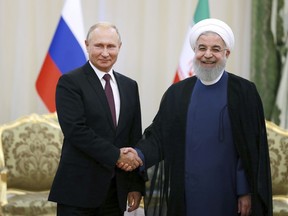 Iran's President Hassan Rouhani, right, shakes hands with Russia's President Vladimir Putin, in Tehran, Iran, Friday, after their talks, part of Russia-Iran-Turkey summit to discuss Syria, Friday Sept. 7, 2018. Putin, Erdogan and Iran's President Hassan Rouhani began a meeting Friday in Tehran to discuss the war in Syria, with all eyes on a possible military offensive to retake the last rebel-held bastion of Idlib.