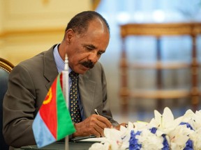 In this photograph released by the state-run Saudi Press Agency, Eritrean President Isaias Afwerki signs a peace accord with Ethiopia in Jiddah, Saudi Arabia on Sunday, Sept. 16, 2018.