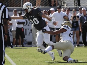 Central Florida quarterback McKenzie Milton (10) holds the ball over the goal line to score a touchdown on a 5-yard run past Pittsburgh linebacker Elijah Zeise, right, during the first half of an NCAA college football game, Saturday, Sept. 29, 2018, in Orlando, Fla.