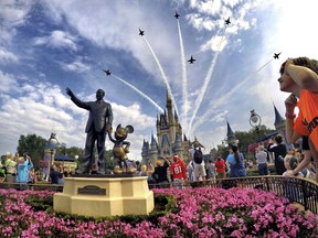 FILE- In this April 16, 2017 file photo, the Blue Angels, the U.S. Navy's legendary flight performance squadron, fly in formation over Cinderella Castle and the 'Partners' statue at the Magic Kingdom at Walt Disney World, in Bay Lake, Fla. Florida emergency officials said Thursday, Sept. 13, 2018, they had no way of tracking how many residents from the Carolinas had escaped to Florida this week. But some hotels were offering special discounts for evacuees and Florida ports were opening their terminals to cruise ships making unexpected ports of call.