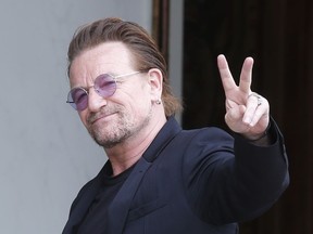 FILE - In this Monday, July 24, 2017 file photo, U2 singer Bono makes a peace sign as he arrives for a meeting at the Elysee Palace, in Paris, France.