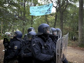 Police officers stand in the Hambach forest near Kerpen, western Germany, Thursday, Sept. 13, 2018.  which is occupied by protestors to stop from being chopped down for a lignite strip mine.