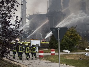 Firefighters walk over the area of a Bayernoil refinery in Vohburg an der Donau near Ingolstadt, southern Germany, Saturday, Sept. 1, 2018 after a fire broke out.