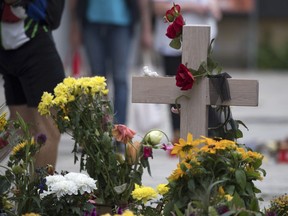 A cross is decorated with flowers in Chemnitz, eastern Germany, Saturday, Sept. 1, 2018, at the site where 35-year-old man was stabbed the Sunday before.