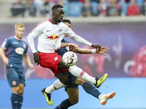 Leipzig's Jean-Kevin Augustin and Duesseldorf's Kaan Ayman challenge for the ball during the German Bundesliga soccer match between RB Leipzig and Fortuna Duesseldorf in Leipzig, eastern Germany, Sunday, Sept. 2, 2018.