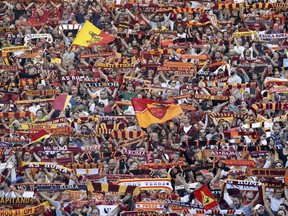 Roma supporters wave scarves and flags prior to the Serie A soccer match between Roma and Lazio, at the Rome Olympic Stadium, Saturday, Sept. 29, 2018.