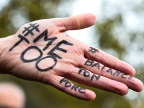 This file photo taken on October 29, 2017 shows  A picture shows the messages "#Me too" and #Balancetonporc ("expose your pig") on the hand of a protester during a gathering against gender-based and sexual violence called by the Effronte-e-s Collective, on the Place de la Republique square in Paris on October 29, 2017.