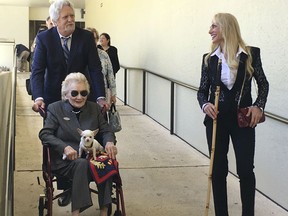 FILE - In this March 15, 2018 file photo, Abigail Kawananakoa, a 91-year-old Hawaiian heiress, is wheeled from a Honolulu courtroom. Board members of a foundation a 92-year-old heiress established for Native Hawaiians are calling for a judge to protect her $215 million trust. Many Native Hawaiians consider Abigail Kawananakoa to be the last Hawaiian princess because of her lineage. Her wealth is embroiled in a legal fight and a key court hearing is scheduled for Monday, Sept. 10, 2018.