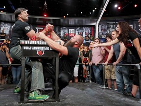 Devon Larratt, of Big Island, Ontario, Canada, left, competes against Michael Todd, of Hot Springs, Ark., in the heavyweight class as Larratt's wife Jodi, right, shouts from the corner during the World Armwrestling League Championships in Atlanta, Wednesday, Sept. 5, 2018.