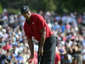 Tiger Woods motions for his putt for birdie to slow down as it passes the ninth hole during the final round of the Tour Championship golf tournament Sunday, Sept. 23, 2018, in Atlanta.