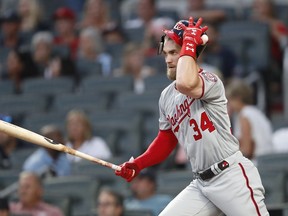 Washington Nationals' Bryce Harper (34) follows through on a base hit in the first inning of a baseball game against the Atlanta Braves Friday, Sept. 14, 2018, in Atlanta.