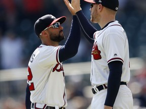 Atlanta Braves' Freddie Freeman (5), right, and Nick Markakis (22) celebrate after defeating St. Louis Cardinals 7-3 in a baseball game Wednesday, Sept. 19, 2018, in Atlanta.