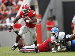 Georgia running back Elijah Holyfield (13) breaks through the Middle Tennessee defense for a big gain in the first half of an NCAA college football game Saturday, Sept. 15, 2018, in Athens, Ga.