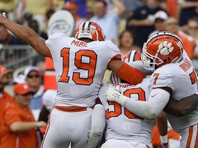 Clemson defensive end Clelin Ferrell (99) celebrates his touchdown against Georgia Tech with Clemson safety Tanner Muse (19) and Clemson defensive end Austin Bryant (7) during the first half of an NCAA college football game, Saturday, Sept. 22, 2018, in Atlanta.