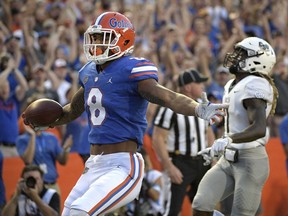 Florida wide receiver Trevon Grimes (8) celebrates after running into the end zone for a 34-yard receiving touchdown in front of Charleston Southern defensive back Brandon Rowland (7) during the first half of an NCAA college football game, Saturday, Sept. 1, 2018, in Gainesville, Fla.