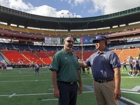 Hawaii head coach Nick Rolovich and Navy head coach Ken Niumatalolo chat during pregame warmups before the start of an NCAA college football game, Saturday, Sept. 1, 2018, in Honolulu. Both coaches are former quarterbacks of the Hawaii Warriors.