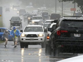 A couple walks in a rainstorm amid heavy traffic in Paia, Hawaii, on Tuesday, Sept. 11, 2018, as Tropical Storm Olivia marched closer to Maui. Olivia was expected to pass directly over Maui on Tuesday night into Wednesday morning.