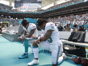 Miami Dolphins wide receiver Kenny Stills (10) and Miami Dolphins wide receiver Albert Wilson (15) kneel during the national anthem before an NFL football game against the Tennessee Titans, Sunday, Sept. 9, 2018, in Miami Gardens, Fla.