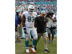Miami Dolphins defensive tackle Akeem Spence (93) is escorted off the field after a play during the first half of an NFL football game against the Oakland Raiders, Sunday, Sept. 23, 2018, in Miami Gardens, Fla.