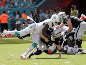 Miami Dolphins defensive end William Hayes (95) sacks Oakland Raiders quarterback Derek Carr (4) during the first half of an NFL football game, Sunday, Sept. 23, 2018 in Miami Gardens, Fla.