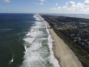 In this Monday afternoon, Sept. 10, 2018 photo provided by DroneBase, waves crash along Avon, N.C., in the Outer Banks ahead of Hurricane Florence. Florence churned Tuesday, Sept. 11, toward the Eastern Seaboard as a storm of "staggering" size, forcing a million people to evacuate the coast.
