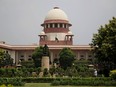 n this Aug. 22, 2017 file photo, a gardener works in the lawns of the Supreme Court in New Delhi, India.