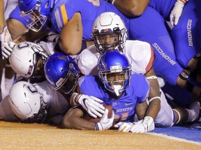 Boise State wide receiver Akilian Butler (81) looks up from under the pile of players he dragged in to the end zone for a touchdown against Connecticut in the second half of an NCAA college football game, Saturday, Sept. 8, 2018, in Boise, Idaho. Boise State won 62-7.