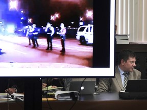 Chicago police Officer Jason Van Dyke listens at right during the second day of his murder trial for the 2014 killing of Laquan McDonald on Tuesday, Sept. 18, 2018, as a video image of McDonald body lying in the street is displayed in court at the Leighton Criminal Court Building in Chicago.