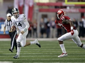 Michigan State quarterback Brian Lewerke is chased by Indiana's Raheem Layne during the first half of an NCAA college football game, Saturday, Sept. 22, 2018, in Bloomington, Ind.