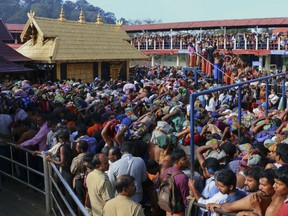 In this Dec. 1, 2015 file photo, Hindu worshippers stand in long queues outside the Sabarimala temple in the southern Indian state of Kerala. India's Supreme Court on Friday, Sept. 28, 2018, lifted the temple's ban on women of menstruating age, holding that equality is supreme irrespective of age and gender. The historic Sabarimala temple had barred women age 10 to 50 from entering the temple that is one of the largest Hindu pilgrimage centers in the world.