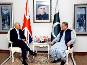 In this photo released by the Press Information Department, Pakistani Foreign Minister Shah Mahmood Qureshi, right, meets visiting British Home Secretary Sajid Javid at the Foreign Ministry in Islamabad, Pakistan, Monday, Sept. 17, 2018. Javid said Monday that the eradication of corruption is a priority for both countries and announced a new partnership between them that would strive for "justice and accountability." (Press Information Department, via AP)
