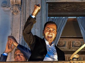 Italian Deputy Prime Minister Luigi Di Maio celebrates on a balcony of Chigi Palace at the end of a cabinet meeting where the government announced its first financial targets, in Rome, late Thursday, Sept. 27, 2018.