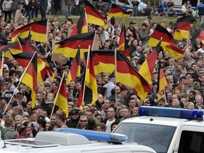 People wave with German national flags during a demonstration in Chemnitz, eastern Germany, Friday, Sept.7, 2018, after several nationalist groups called for marches protesting the killing of a German man two weeks ago, allegedly by migrants from Syria and Iraq.