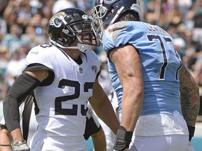 Jacksonville Jaguars defensive back Tyler Patmon (23) confronts Tennessee Titans offensive tackle Taylor Lewan (77) after a play during the first half of an NFL football game, Sunday, Sept. 23, 2018, in Jacksonville, Fla.