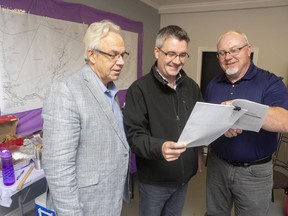 People's Alliance of New Brunswick Leader Chris Austin, centre, talks with campaign supporters Doug Mockler, left, and Reggie Barton at his satellite office in Minto, N.B., on Monday, Sept. 24, 2018.