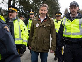 NDP MP Kennedy Stewart, centre, is arrested by RCMP officers after joining protesters outside Kinder Morgan's facility in Burnaby, B.C., on Friday March 23, 2018. As election campaigns kick off across British Columbia its largest city is facing a race unlike any other, experts say.