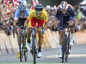 Spain's Alejandro Valverde, center, approaches the finish line to win the men's road race at the Road Cycling World Championships in Innsbruck, Austria, Sunday, Sept.30, 2018.
