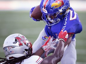 Nicholls State defensive back Jonavon Lewis (27) tries to pull down Kansas wide receiver Stephon Robinson (5) during the first quarter of an NCAA college football game in Lawrence, Kan., Saturday, Sept. 1, 2018.