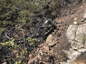 This photo provided by the Coconino County Sheriff's Office, posted Monday, Sept. 17, 2018, shows the burned wreckage of an ATV, found at the bottom of a 400-foot cliff, in the Coconino National Forest in northern Arizona. Authorities say the bodies of four men killed in the fiery crash have been recovered. Coconino County Sheriff's officials say a 10-acre fire and rugged terrain made it difficult for rescuers in the Blue Ridge area to get to the site of Saturday's crash. (Coconino County Sheriff's Office via AP)